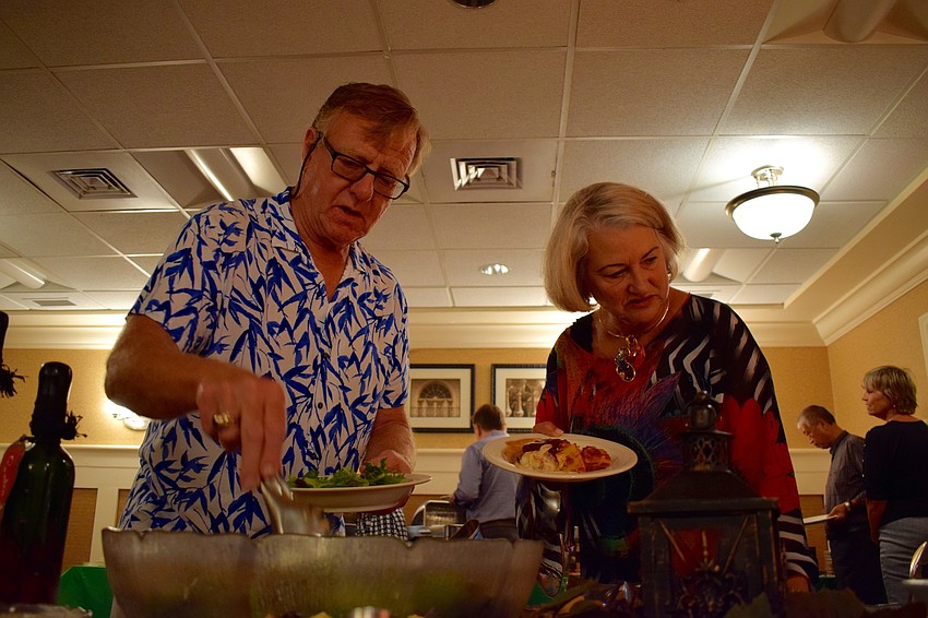 Tara residents Frank Witgen, left, and Linda Barber, right, get salads to add to their Italian dinner during the annual San Gennaro Festival at Tara Golf and Country Club.
