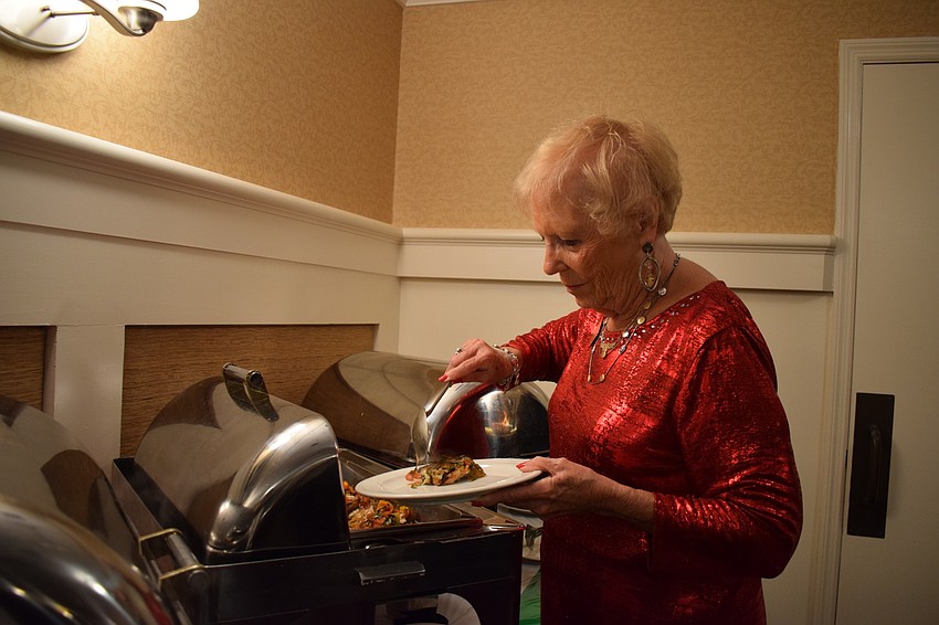 Tara Golf and Country Club's social committee chair Judy Harris puts a serving of chicken caprice on her plate to enjoy during dinner at the club's annual San Gennaro Festival.