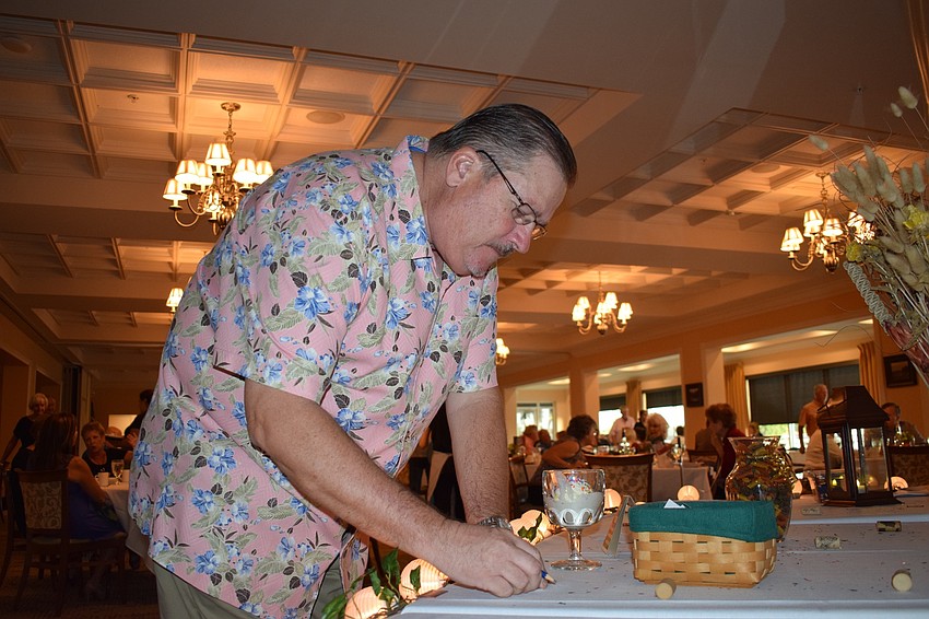 Phil Parsch, president of the Tara Golf and Country Club's board of directors, guesses how many pieces of pasta are in a container before going to enjoy a sundae during the club's annual San Gennaro Festival.