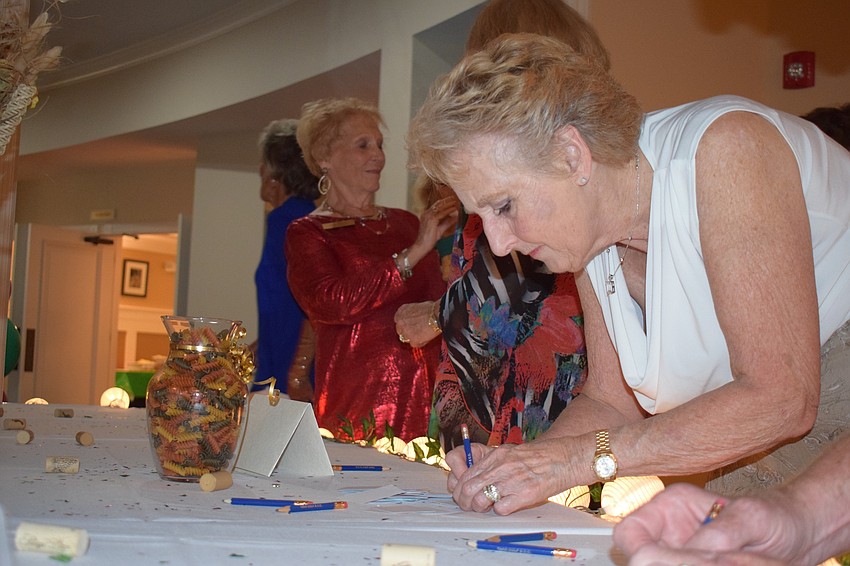 Concession resident Grace Latreille guesses how many pieces of pasta are in a container in hopes of winning a prize during the San Gennaro Festival at Tara Golf and Country Club.