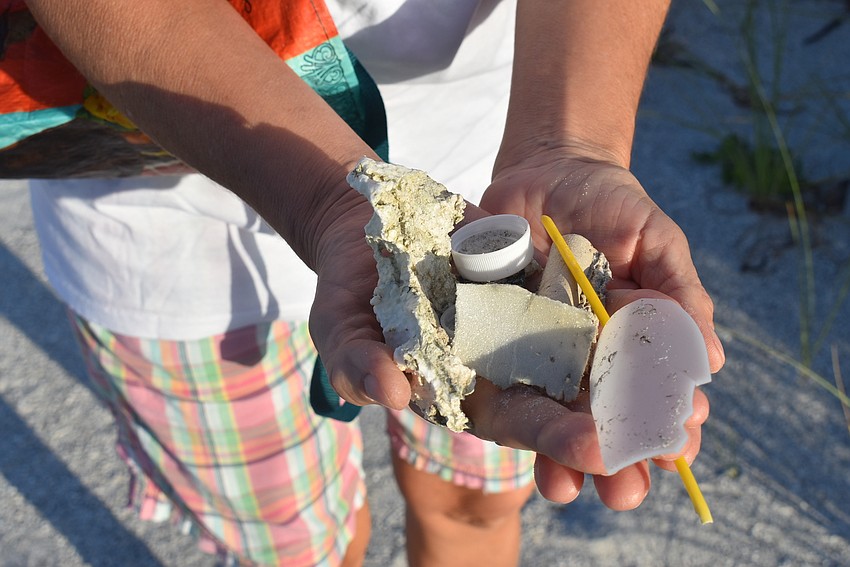 Olga Stokes shows her handful of trash before tallying it up.