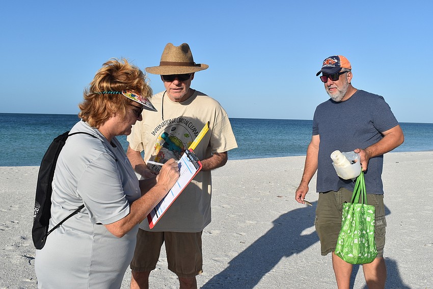 A long line: Dawn DiFoggio notes the trash that Peter Stokes and Charles Kaine bring to her.