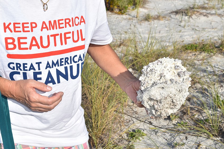 Olga Stokes shows one of the bigger pieces of trash found.