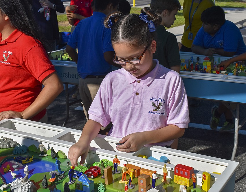 Ashely Gimenez rearranges the cars on the edge of the watershed.