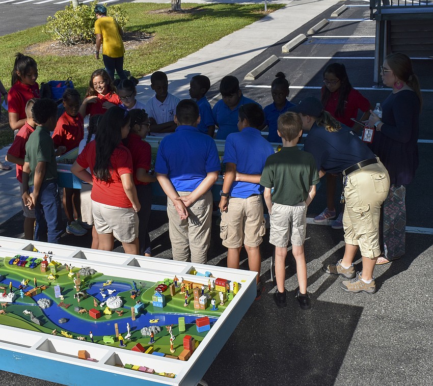 The fifth grade class huddles around one of the watersheds.