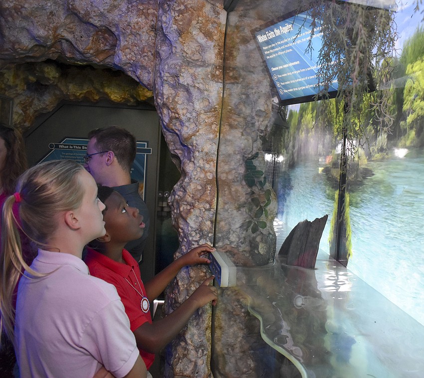 Lillin Williamson and Charleston Hamilton read about how water leaves an aquifer.