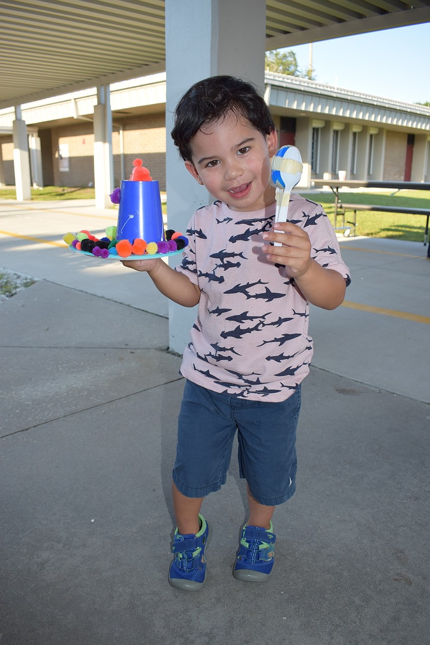 Pre-kindergartner David Bracho, 3, smiles while holding the sombrero he made and shaking his maraca as he waits for his 7-year-old brother, Hector, a second-grader, to finish making a Bibliburro.