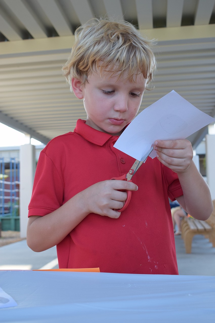Kindergartner Max DeGrave focuses on cutting out a donkey to make a Bibliburro, a traveling library that gives out books from the back of donkeys. 