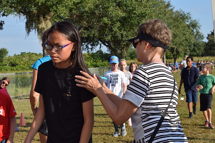 Fifth-grader Emely Chen goes past volunteer Debbie Greenwald, who marks her fifth lap.