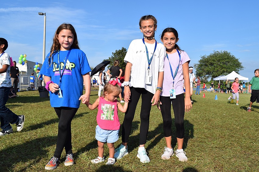 Fourth-grader Isabella Navas, 19-month-old Presley Pell and fourth-graders Kylie Miller and Liani Moran walk together.