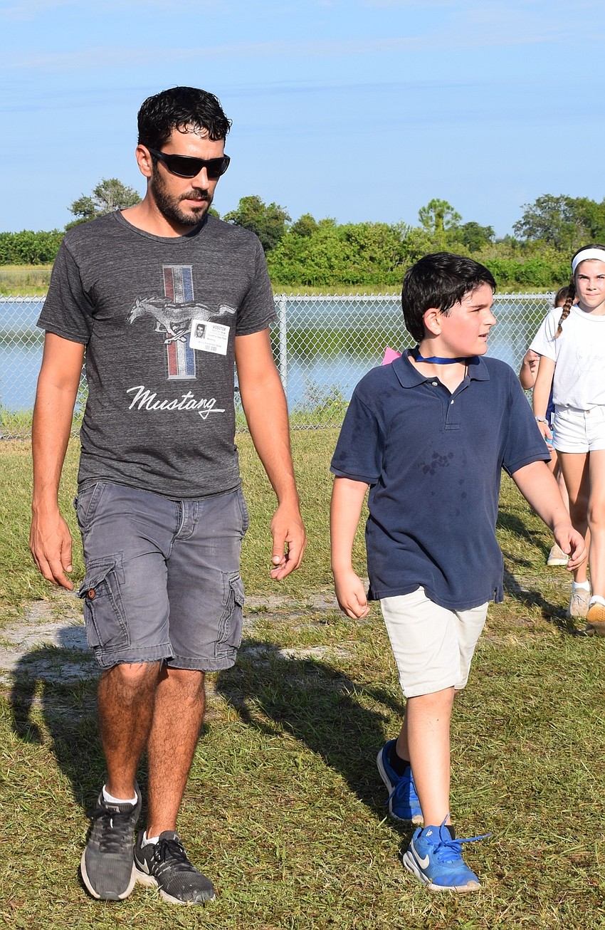 Godefroy Segui Pourel, left, walks with his fourth-grade son Julien. Both of them said they enjoyed being able to spend time with each other during the event.