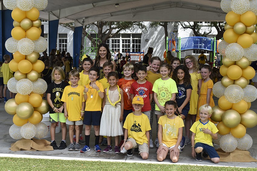 A third grade class posed for a photo in between the balloons columns.