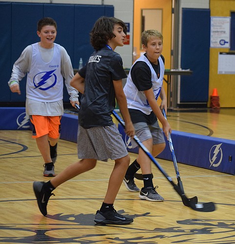 Wyatt Hossenlopp, runs after the ball while Jake Morales and Aidan Levine fight for it during a scrimmage game of hockey.