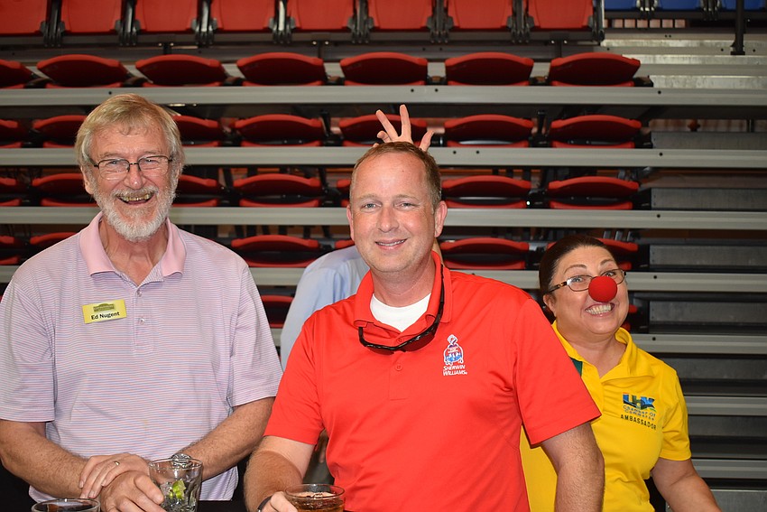 Ed Nugent and Jimmy Bonner pose while Debbie Shaffer runs by in her red clown nose.