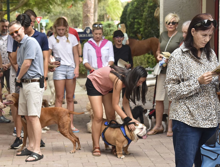 The congregation calms their dogs as the Fathers give the final blessing.