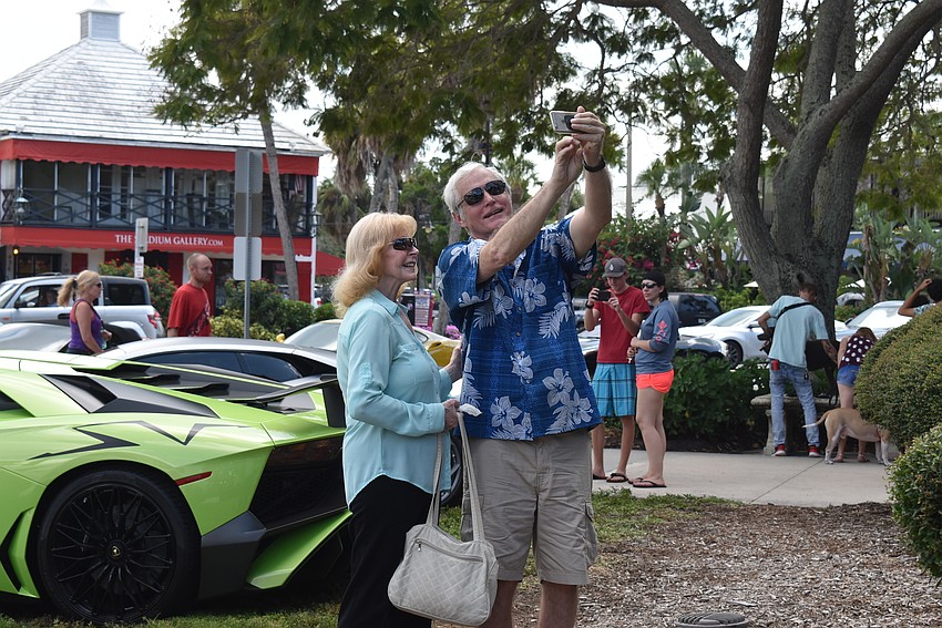 Carlee Miller and Bill Osmer take a selfie with a car.