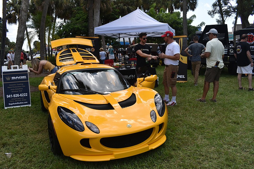 Alex Nodel and Todd MacClinchy chat next to a displayed car.