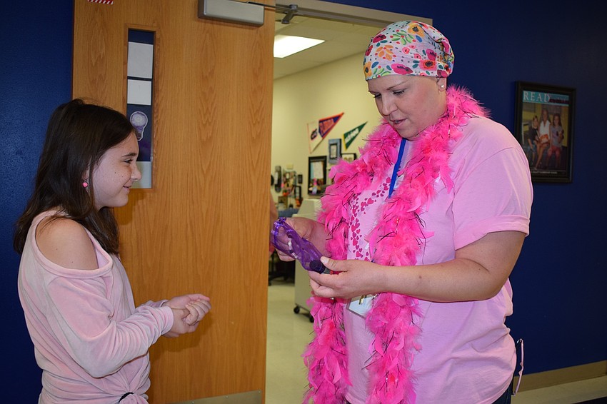 Fourth-grader Jordyn Forest gives a pink bracelet she made to fourth grade teacher Sarah Body. Forest said she wanted to do something nice for Body, so she made the bracelet.