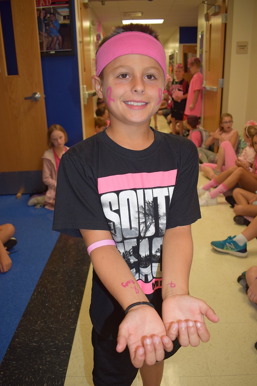 Although Michael Smolka isn't a student of fourth-grade teacher Sarah Body, he had breast cancer awareness ribbons drawn on his arms and face to support her.