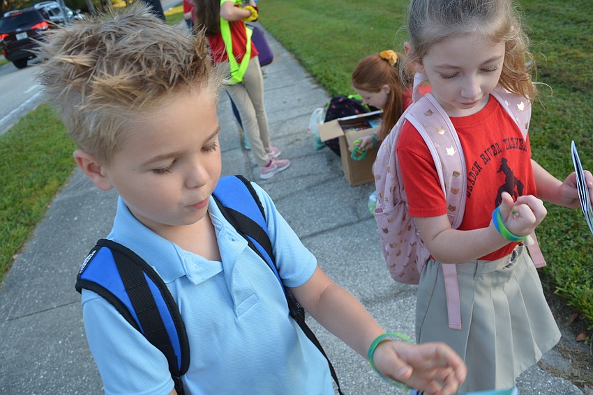 Five-year-olds Nox Newman and Carson Carter are excited to get special bracelets to commemorate the day.