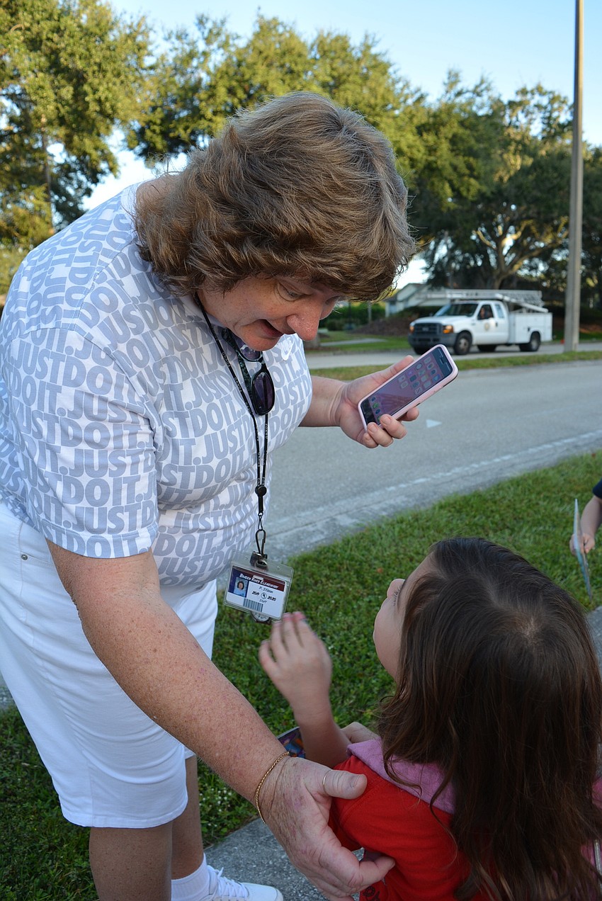 Coach Penny Stilson greets Ella Cochran as she arrives at school.