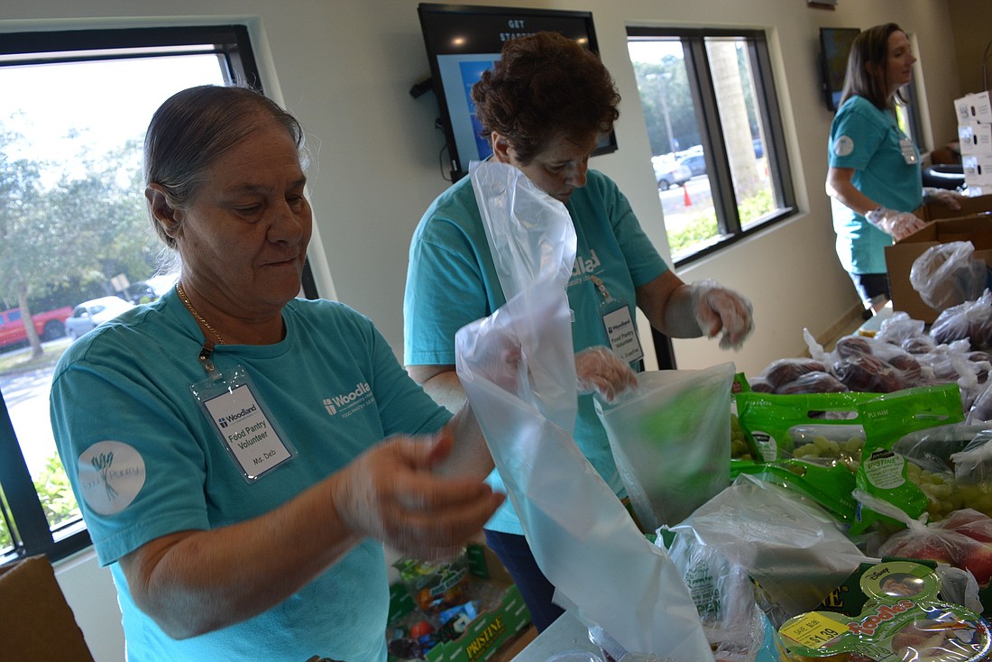 Woodland Community Church food pantry volunteers Debbie Gillette and Josefine Suarez hand out produce. Woodland&#39;s pantry feeds up to 150 families per week.