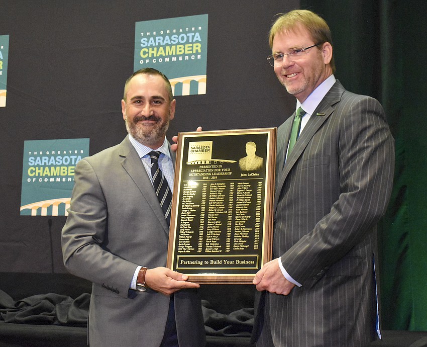 Incoming chamber chair Paul Caragiulo presents outgoing chair John LaCivita with an honorary plaque.