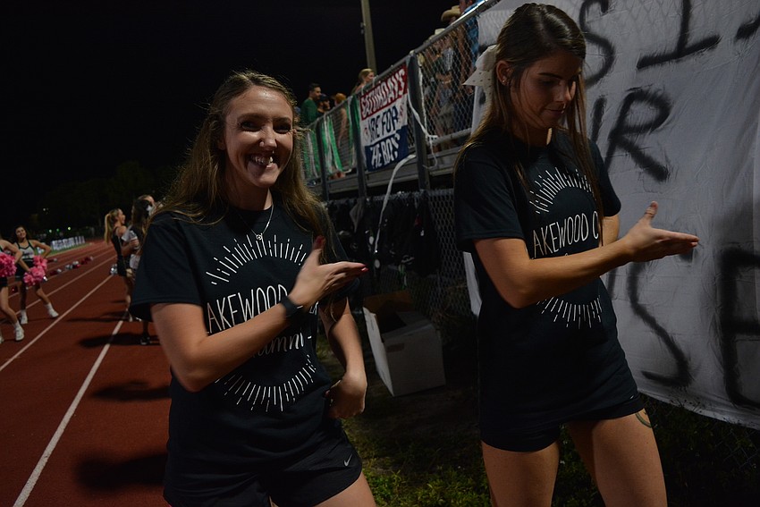 Lakewood Ranch High School alumna Brianna Rowland and Hope Lowe cheer along with the varsity cheerleading squad from the sidelines.