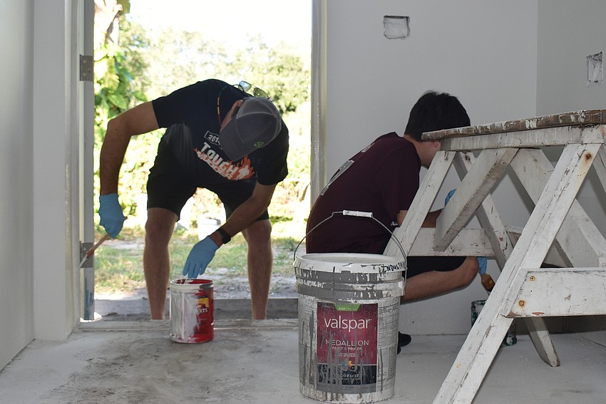 Bob and Zach Stobaugh crouch to paint everywhere.