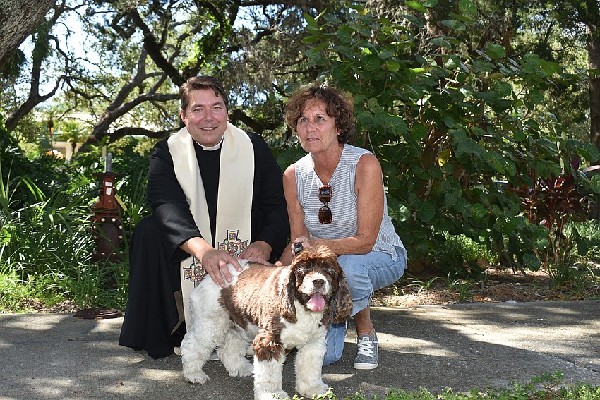 Whitney sits pretty as Father Dave Marshall and Linda Semilof pose with her.