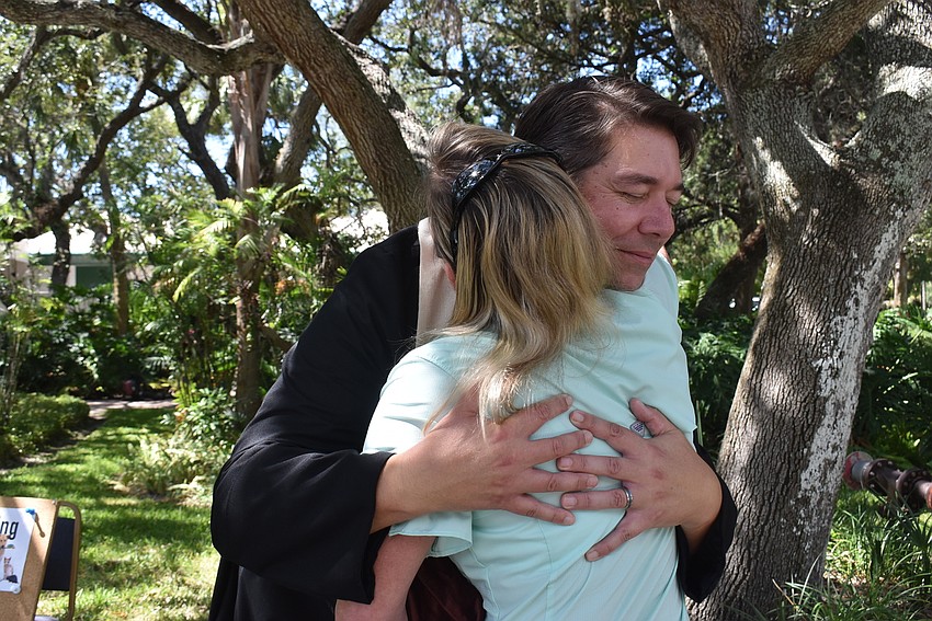 Father Dave Marshall offers condolences to Sandi Drake, whose dog passed away on Sept. 30.