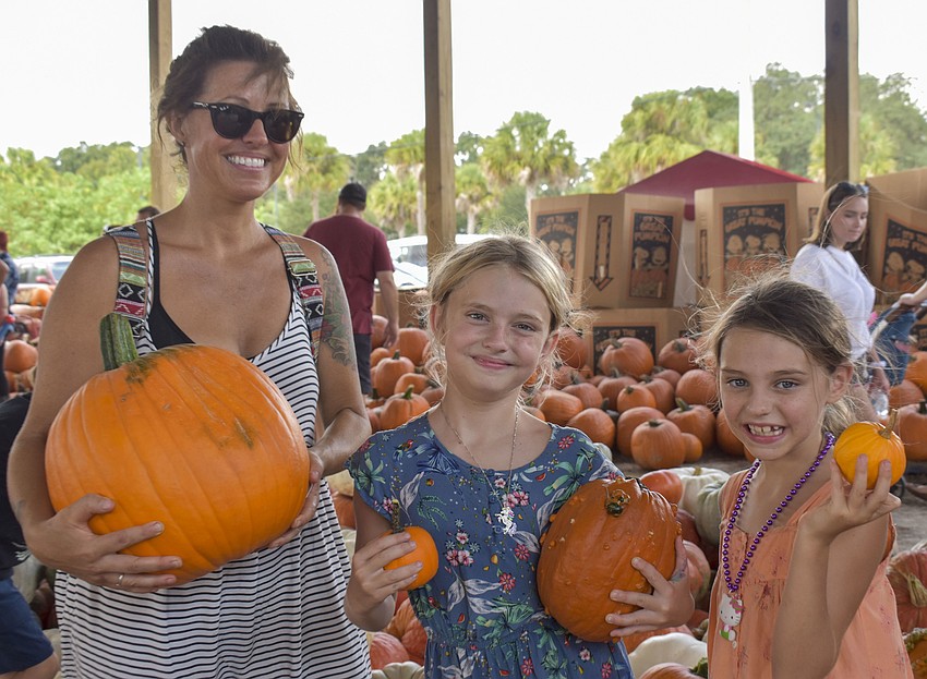 Heather Stubbs and daughters Maya, 8, and Zurie, 7, pose with their pumpkins.