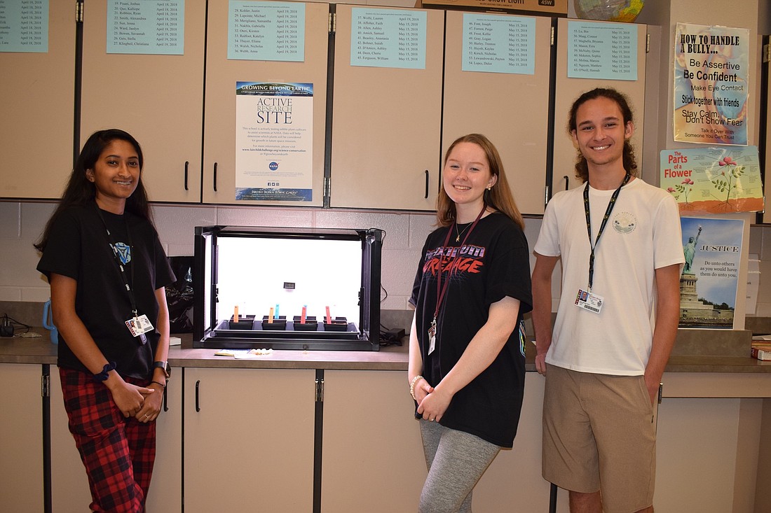 Senior Raisa Matin and juniors Paige Forrest and Fred Rios help to construct the growth chamber used for the Growing Beyond Earth project at Braden River High School. About 140 students will be participating in the NASA project.