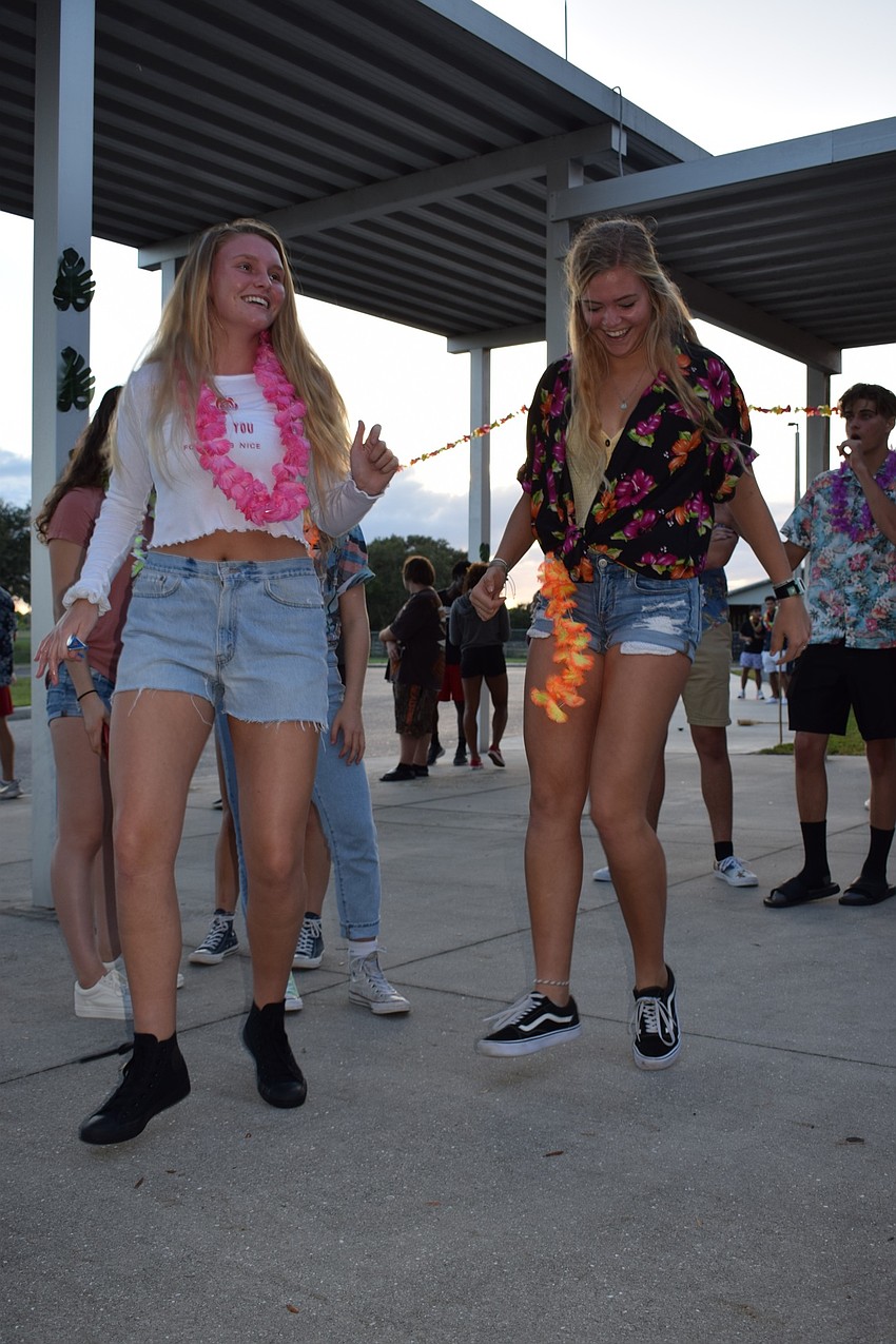 Senior Kayla Keane and junior Sara Hall dance in unison as the homecoming bonfire gets started. Hall said she couldn't wait to be a part of the Student Government Association flash mob, which performed during the event.