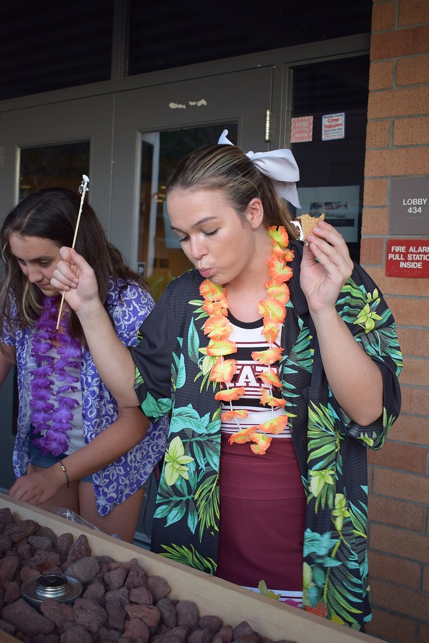 Senior Emily Byrd dances while enjoying a s'more. Byrd said she was going to make her final bonfire the best one ever.
