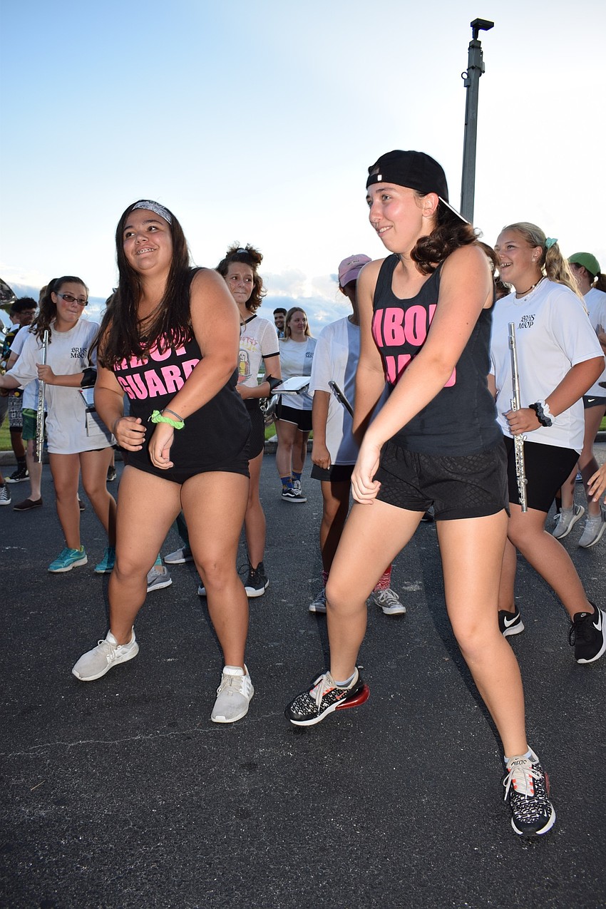 Marching Band of Pirates color guard members junior Natalie Valentine and freshman Grace Scutti dance together while the drumline plays a cadence.