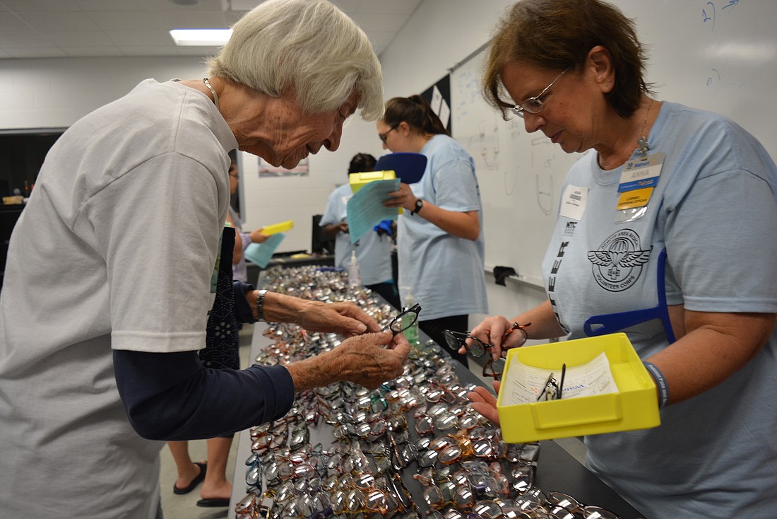 Bradenton 86-year-old Bernita Franzel selects from hundreds of frames with the help of volunteer optician Anna Seigneurie.  Glasses were made on site so Franzel could take home her new pair.