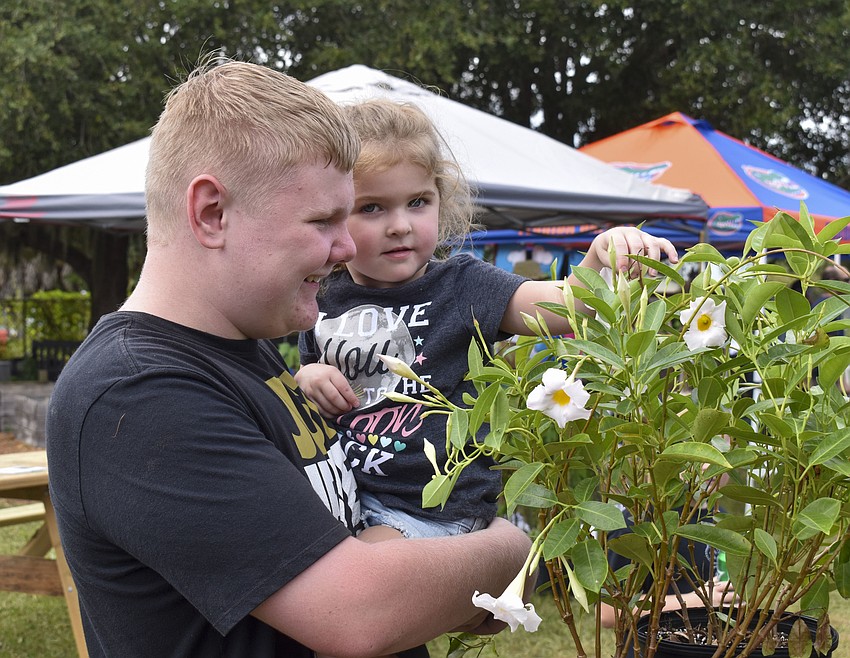 Dakota Arnold and Zoey Chamberlain, 3, look at flowers together.
