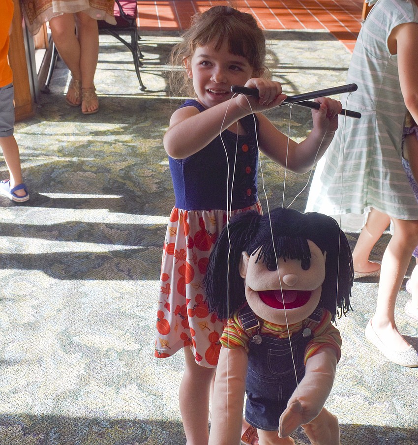 Abbey Granata, 5, tries out the marionette.