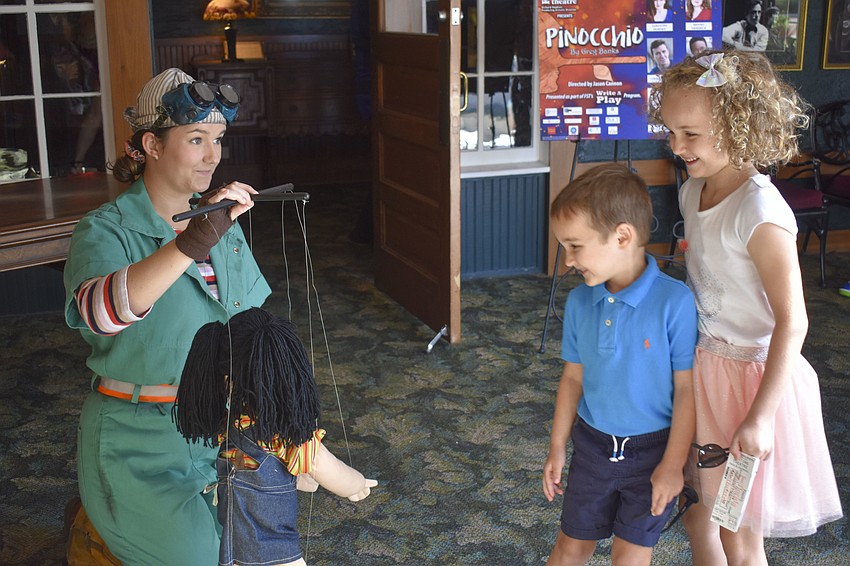 Reilly O'Connell introduces siblings Maksim, 4, and Mila Zivkovic, 7, to one of the marionettes.