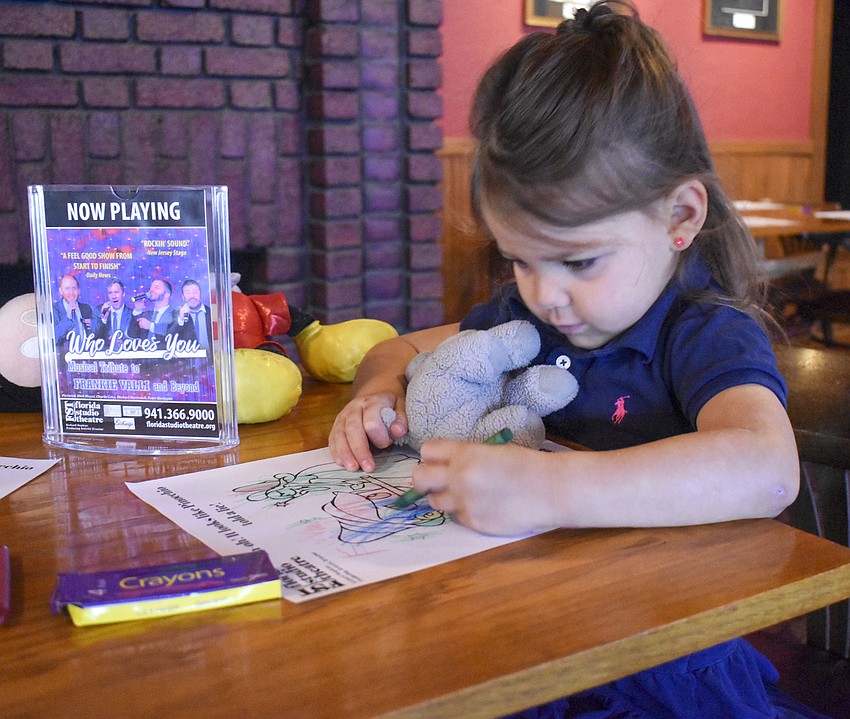 Emma Windrum, 4, colors before the play begins.