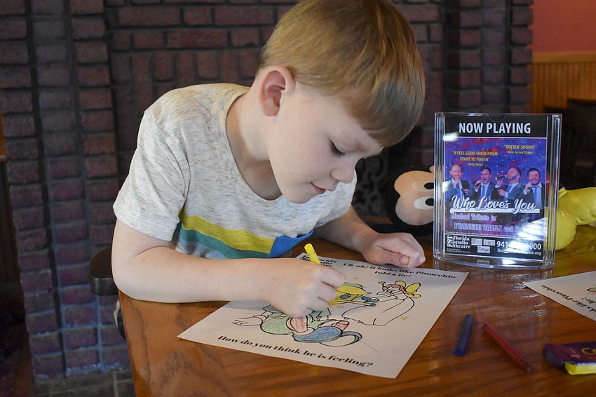 Thomas Windrum, 6, adds some yellow to his drawing.