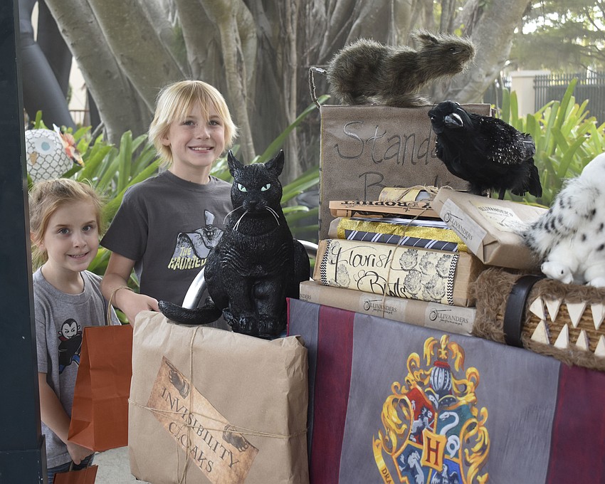 Finley and Banning Kile pretend to push Harry Potter's luggage cart.
