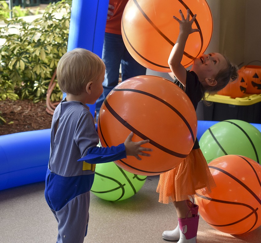 Jacob Lamena and Lucca Trattles play in the oversized basketball hoop.