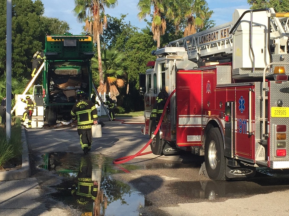 Firefighters were working on putting out a fire in the hopper of a Waste Management trash truck on Tuesday morning.