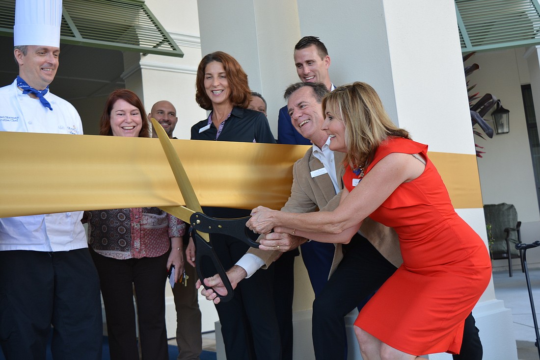 Grand Living officials and staff cut a ceremonial ribbon to  celebrate the community&#39;s opening.