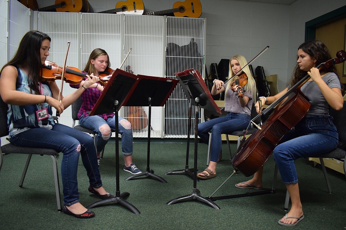 Juniors Mikayla Stokes and Brianna Noon and seniors Lucy Crank and Angelina Ortiz practice playing together as a quartet. With different schedules, finding times to practice can be difficult.