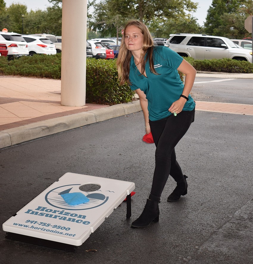 Jordan Augustyniak, with Horizan Insurance, plays a game of cornhole with her sister, Taylor.