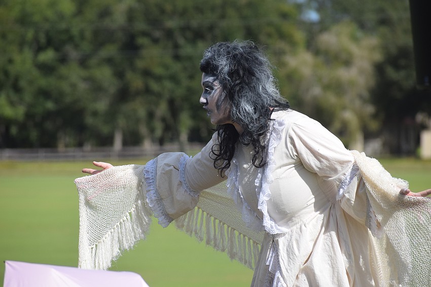 The Woman in White (Yvonne Clark) takes a spooky walk through the crowd.