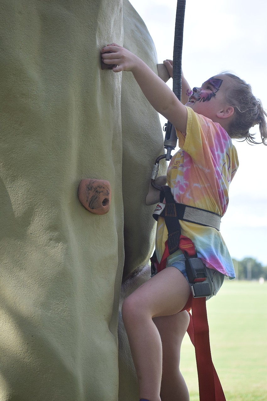 Lakewood Ranch 5-year-old Ellie Turner tests her climbing skills on a wall brought to the event by Within Reach of Bradenton.
